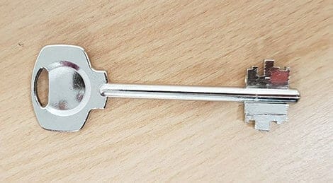 a silver safe key with double bitted end