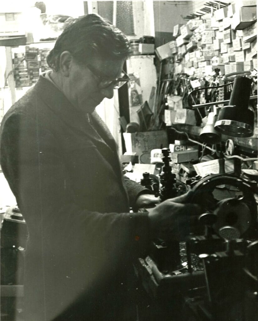 Ray Ward operating a key cutting machine, focused on shaping a key blank.