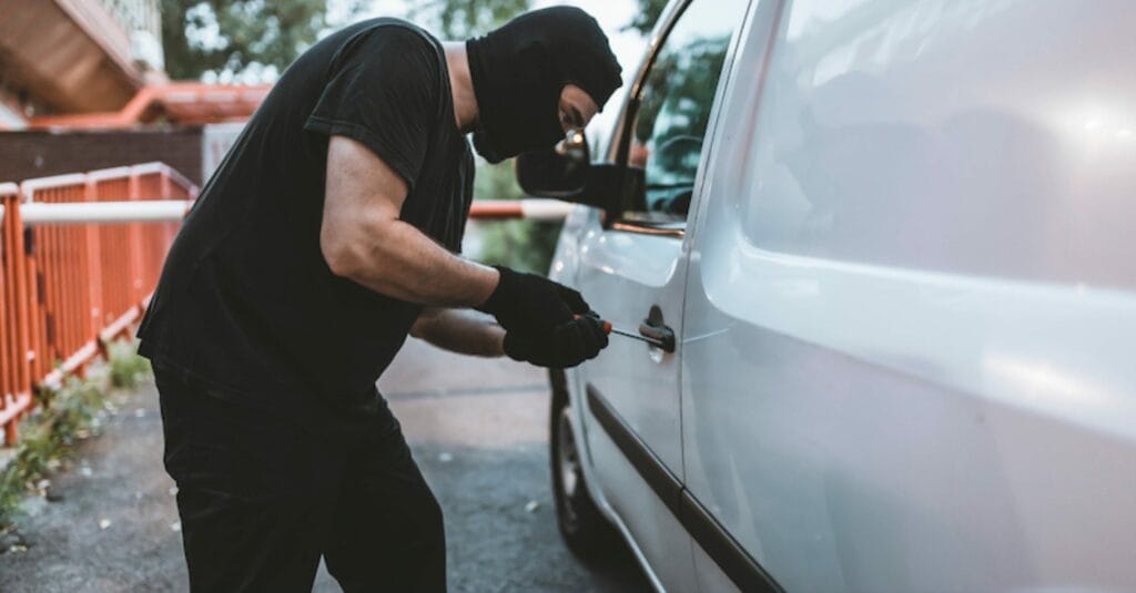 Thief breaking into a white van